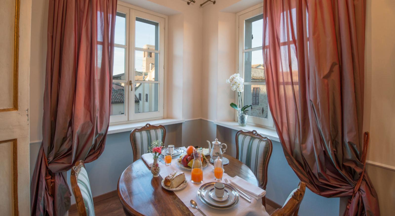 Accogliente sala da pranzo con colazione servita e vista sulle case.