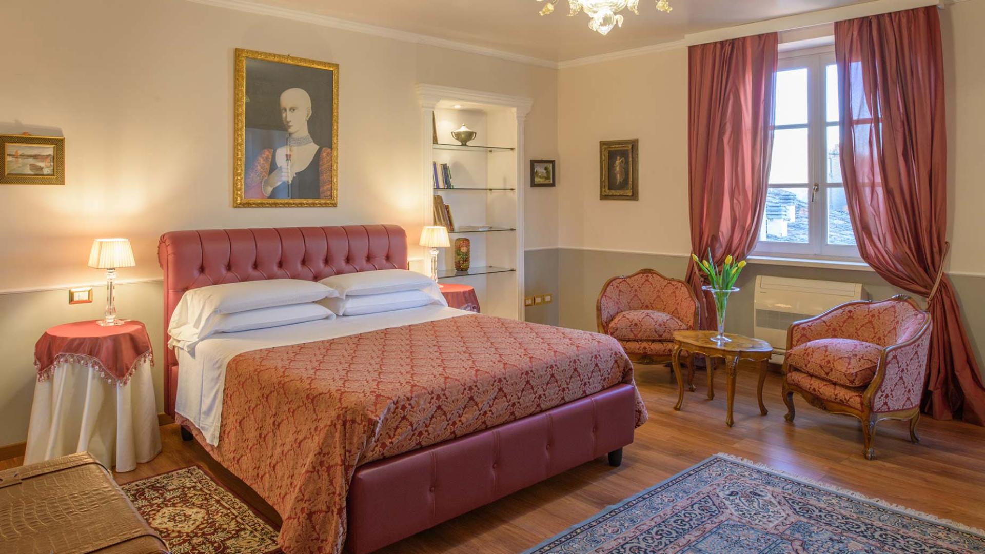Elegante camera da letto con arredi classici e tessuti rossi.