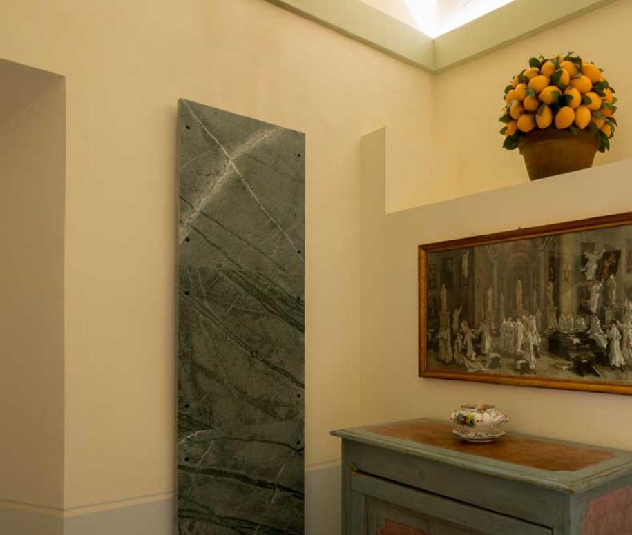 Interno con quadro, vaso di limoni e mobile antico.