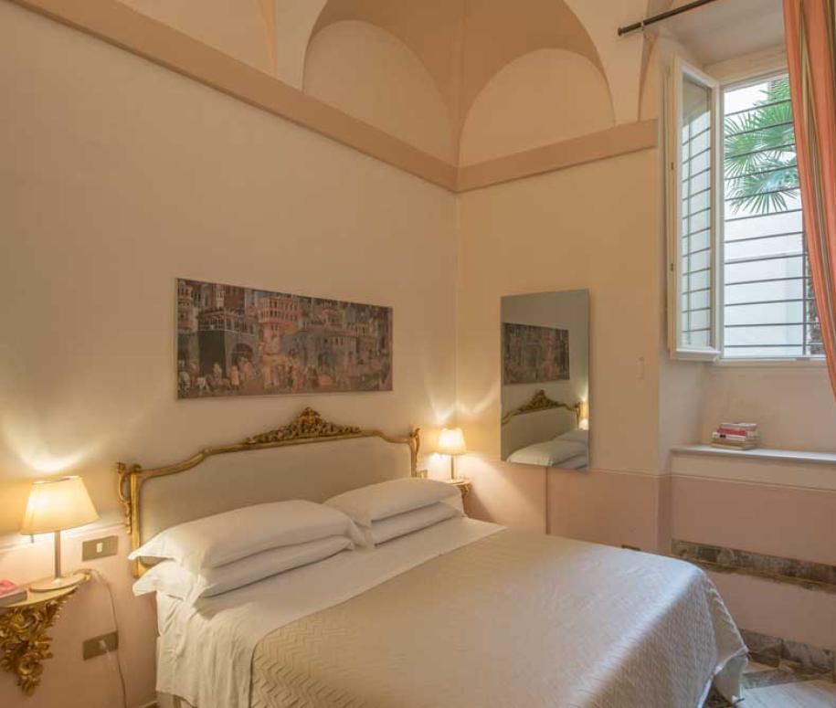 Camera accogliente con letto matrimoniale, decorazioni eleganti e finestra luminosa.