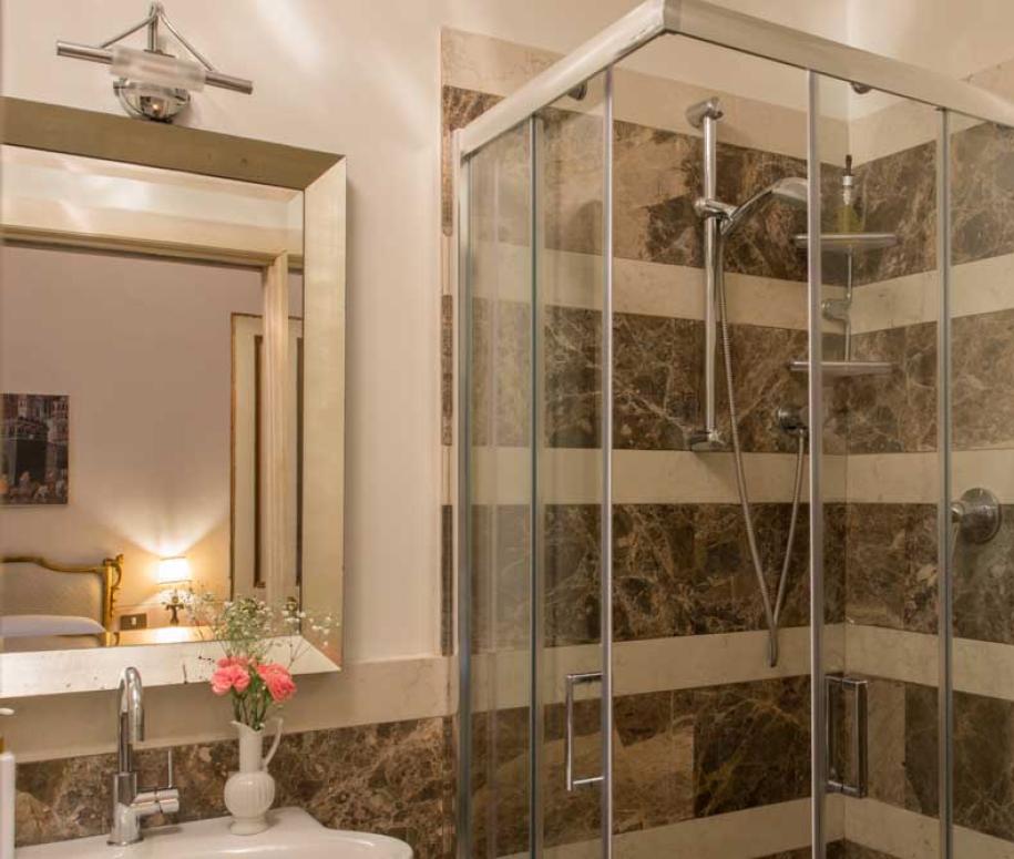 Bagno elegante con doccia moderna e specchio grande.