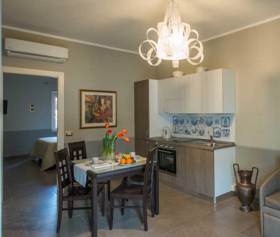 Accogliente cucina con tavolo da pranzo, divano e decorazioni artistiche.