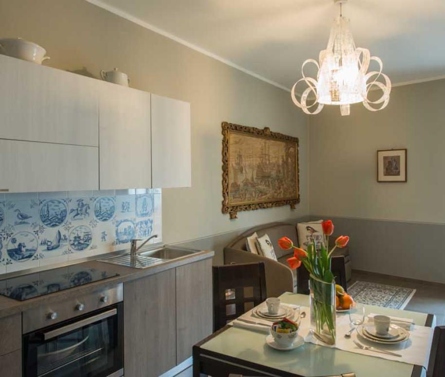 Cucina moderna con decorazioni eleganti, tavolo apparecchiato e lampadario di design.