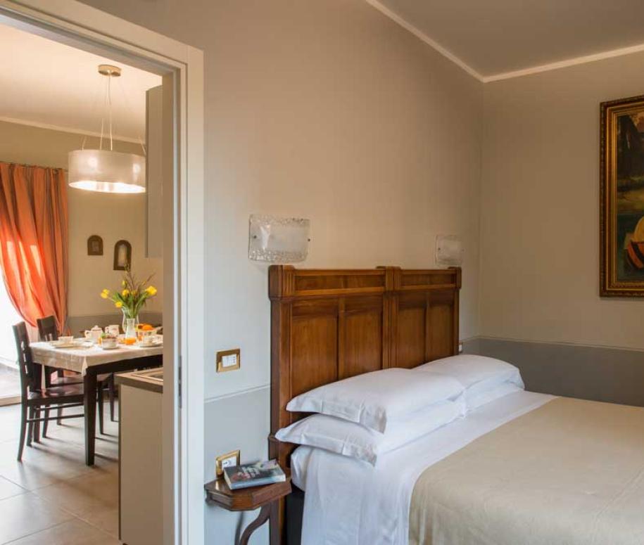 Camera accogliente con letto matrimoniale e dipinto, vista sulla sala da pranzo.