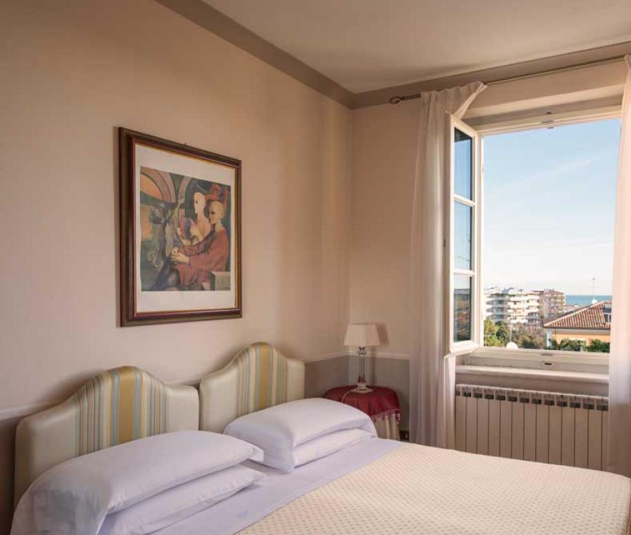 Camera da letto luminosa con vista sul mare e arredamento elegante.