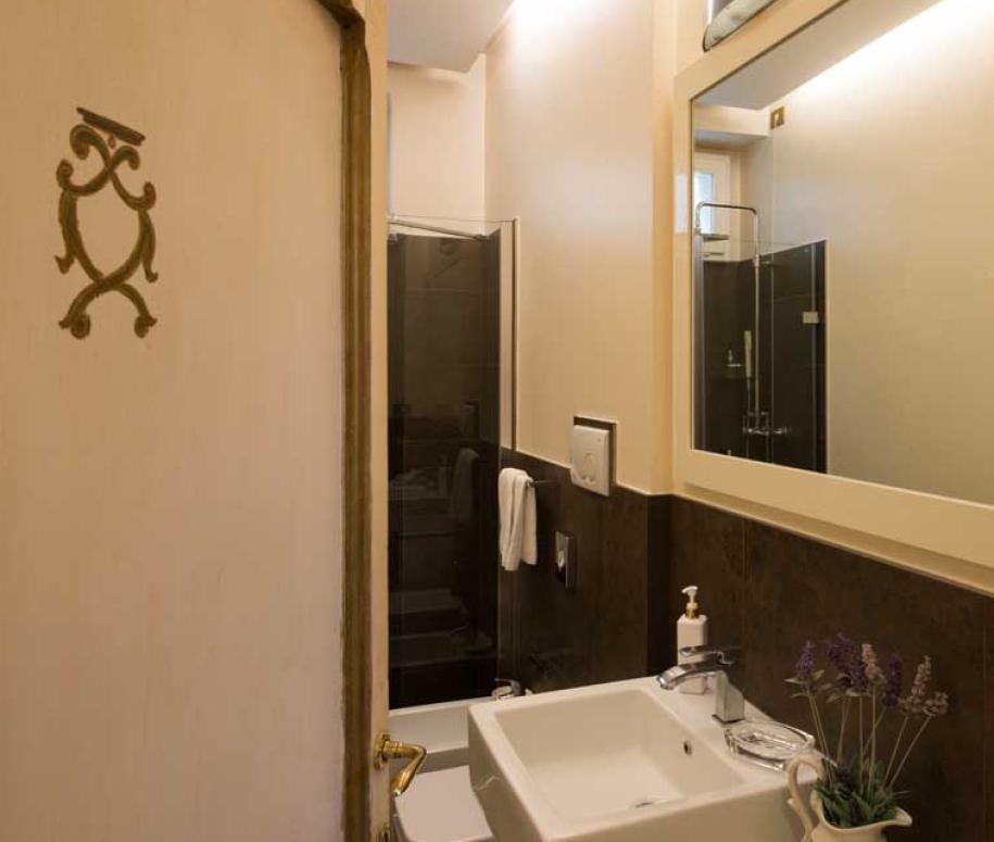 Bagno moderno con doccia in vetro e grande specchio.