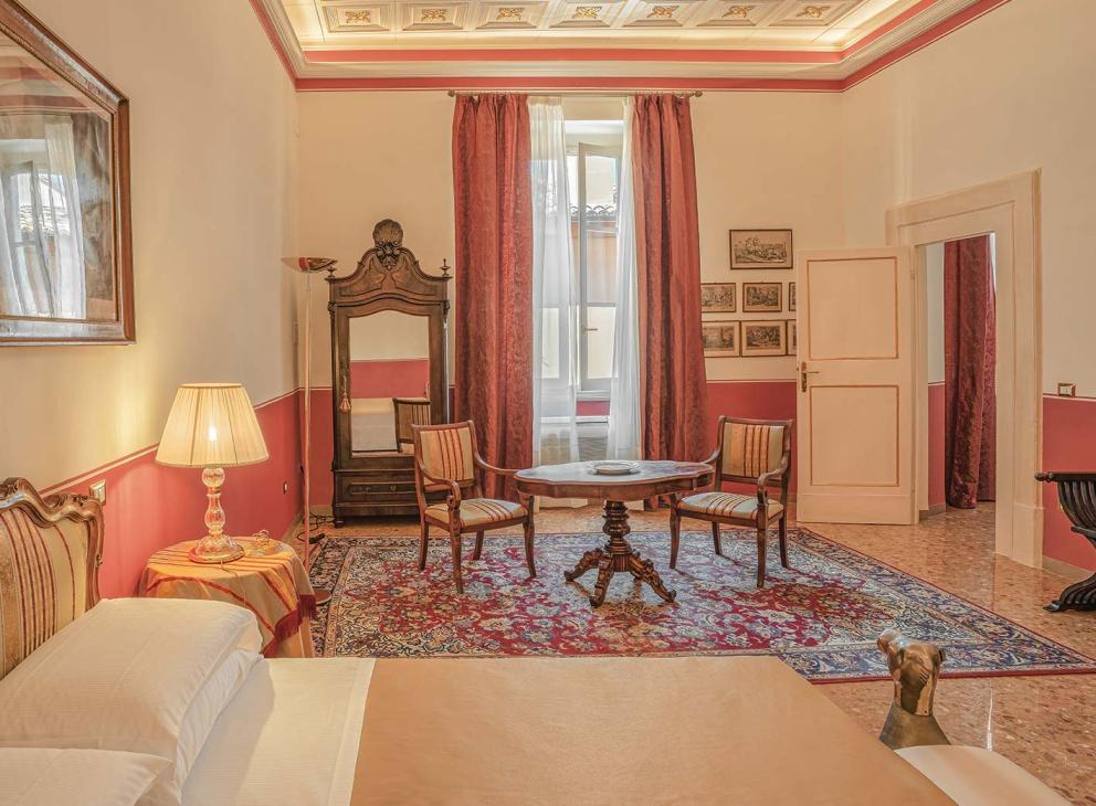 Elegante camera d'albergo con mobili antichi e decorazioni classiche.